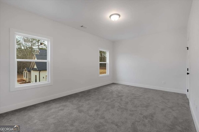 carpeted spare room featuring baseboards and a healthy amount of sunlight