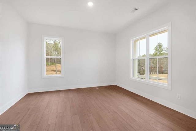 spare room with baseboards and wood finished floors