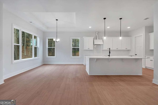 kitchen with white cabinets, light wood-style floors, baseboards, and light countertops