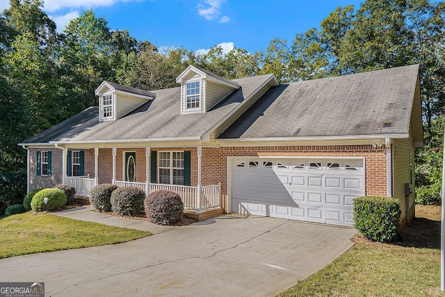 cape cod-style house featuring brick siding, covered porch, concrete driveway, an attached garage, and a front yard