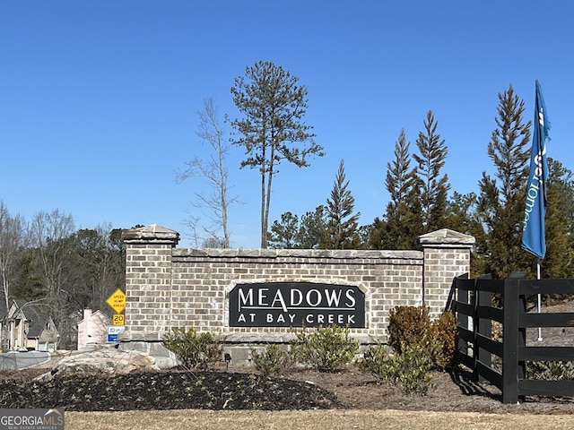 community / neighborhood sign featuring fence