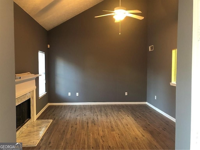 unfurnished living room featuring baseboards, dark wood-style floors, ceiling fan, a fireplace, and high vaulted ceiling