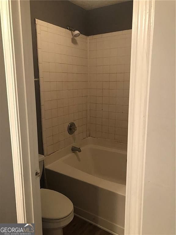 full bathroom with bathtub / shower combination and toilet