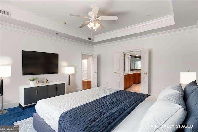 carpeted bedroom featuring a tray ceiling, crown molding, visible vents, a ceiling fan, and baseboards