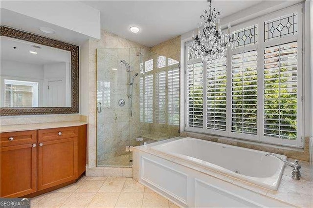 bathroom with a garden tub, vanity, a shower stall, tile patterned floors, and an inviting chandelier