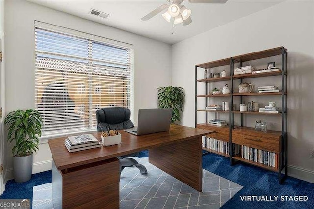 office space featuring ceiling fan, visible vents, and baseboards