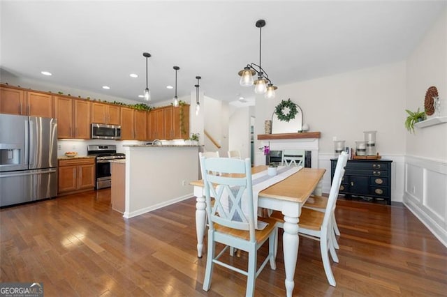 dining area featuring a wainscoted wall, dark wood-style flooring, recessed lighting, and a decorative wall