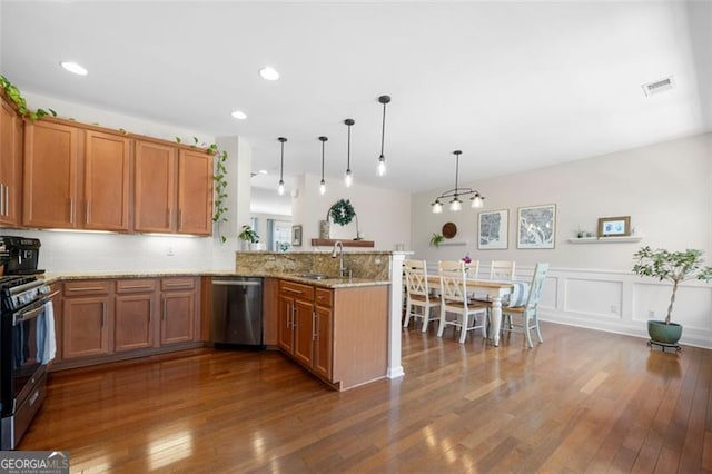 kitchen with dishwasher, range with gas cooktop, brown cabinets, a peninsula, and a sink