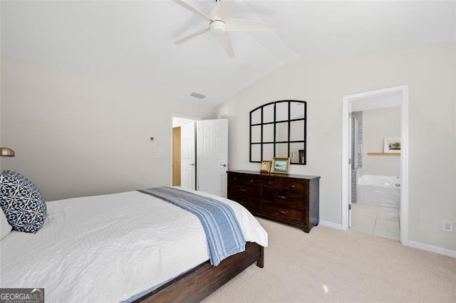 carpeted bedroom with a ceiling fan, vaulted ceiling, ensuite bath, and baseboards