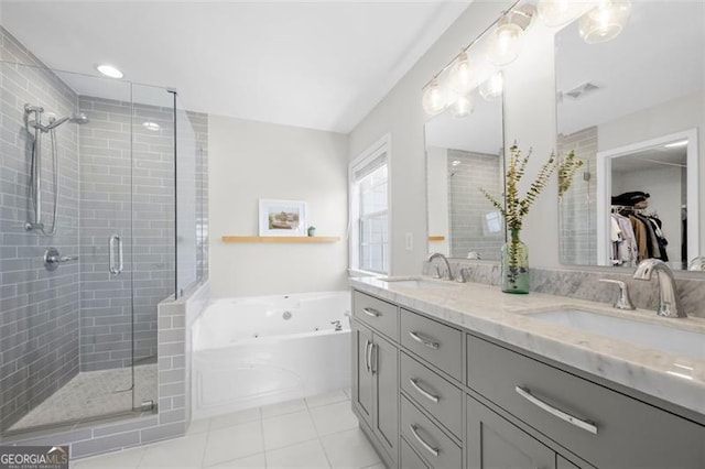 bathroom featuring double vanity, a stall shower, a tub with jets, and a sink