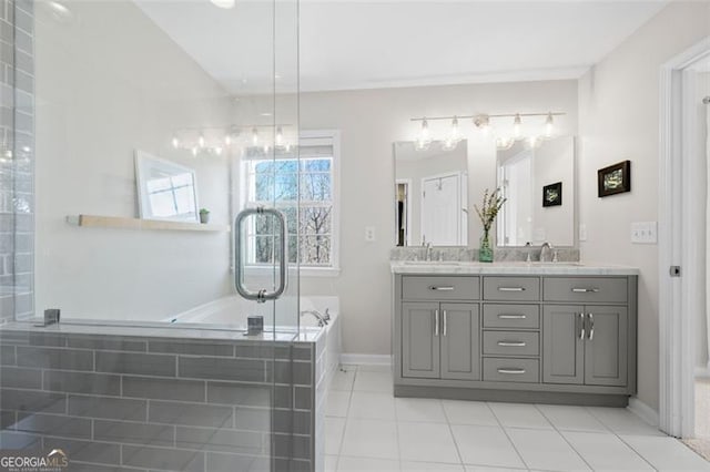 full bathroom featuring double vanity, a sink, a bath, and baseboards