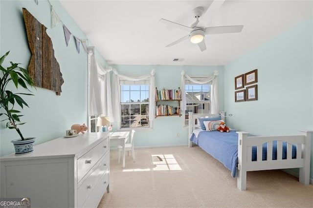 bedroom with light carpet, ceiling fan, visible vents, and baseboards