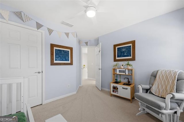 living area featuring baseboards, ceiling fan, visible vents, and light colored carpet