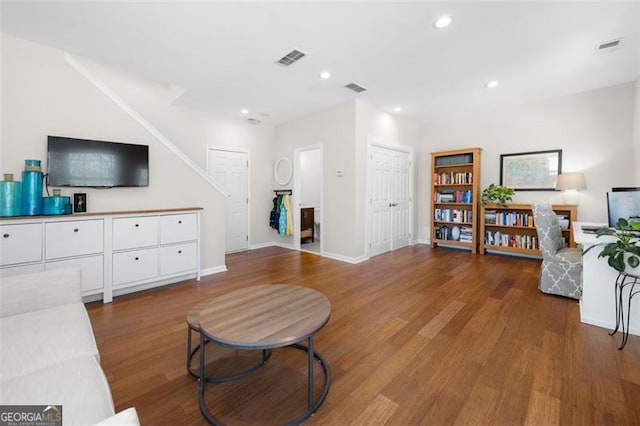 living area with baseboards, wood finished floors, visible vents, and recessed lighting