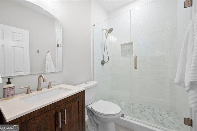 full bathroom with a stall shower, vanity, and toilet