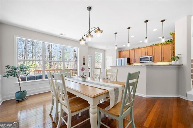 dining space with hardwood / wood-style flooring and recessed lighting