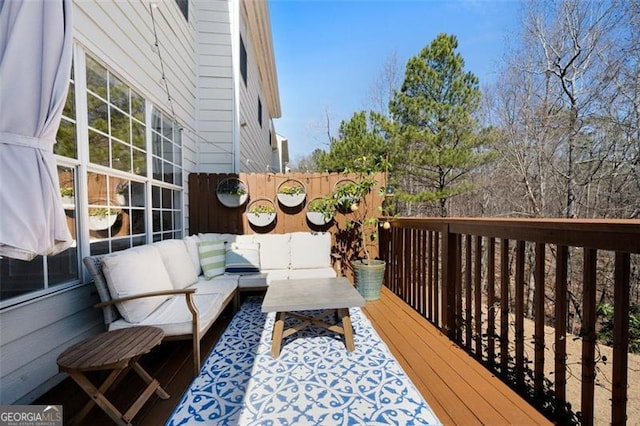 wooden terrace with fence and an outdoor hangout area