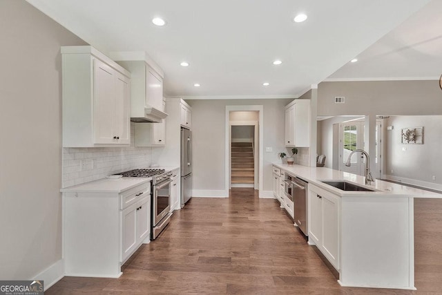 kitchen featuring extractor fan, stainless steel appliances, a peninsula, a sink, and tasteful backsplash