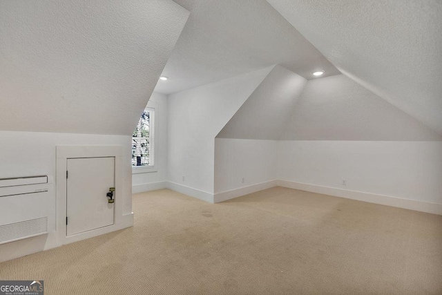 additional living space with baseboards, lofted ceiling, a textured ceiling, carpet flooring, and recessed lighting