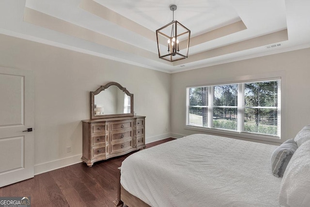 bedroom featuring a notable chandelier, a raised ceiling, visible vents, dark wood-type flooring, and baseboards