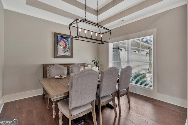 dining area with dark wood-style floors, crown molding, a raised ceiling, and baseboards