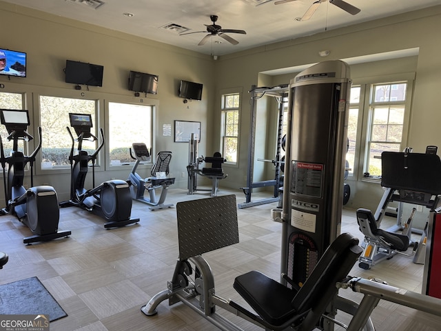 exercise room featuring plenty of natural light, visible vents, and a ceiling fan