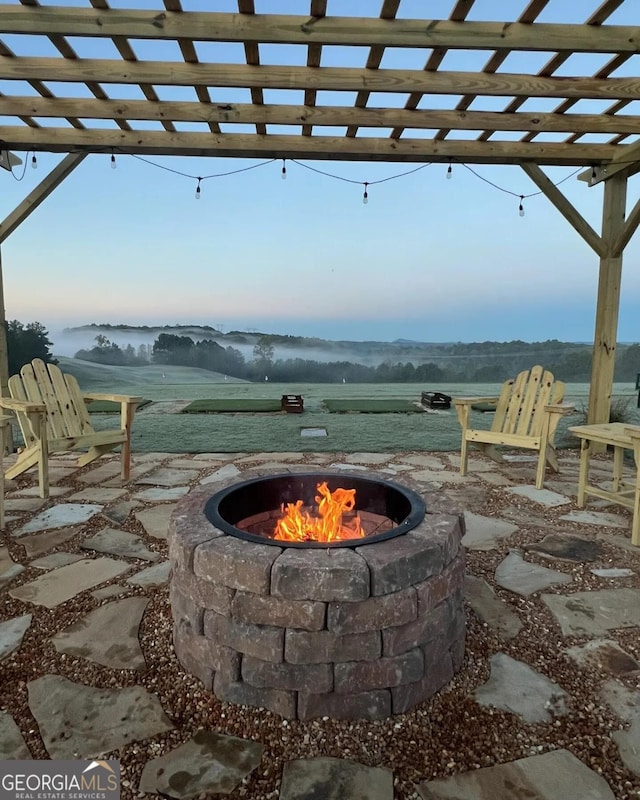 view of patio / terrace featuring an outdoor fire pit and a rural view