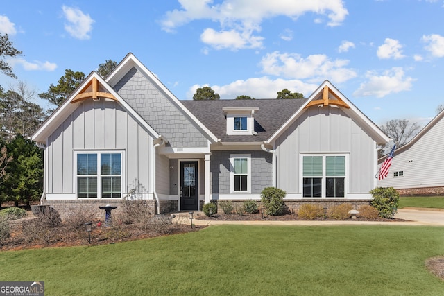 view of front of property with brick siding, a shingled roof, board and batten siding, and a front yard