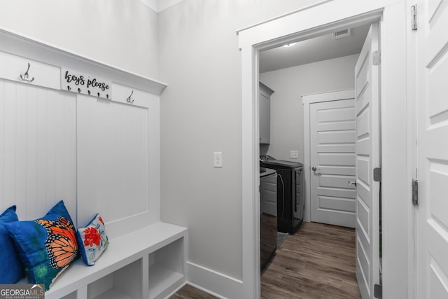 mudroom featuring visible vents, dark wood finished floors, and separate washer and dryer