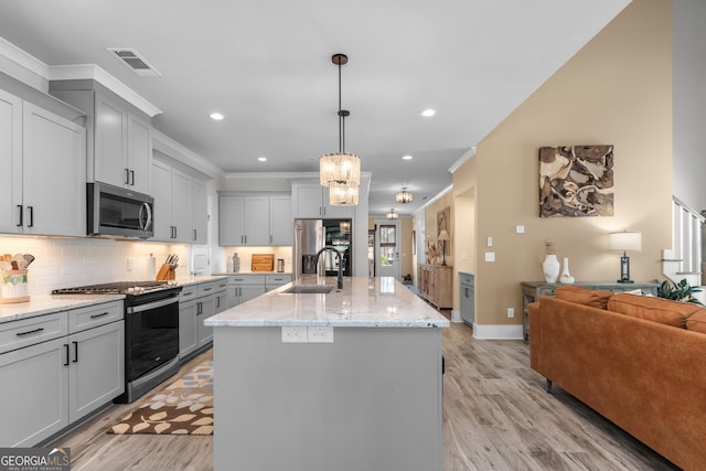 kitchen featuring crown molding, decorative backsplash, stainless steel appliances, and a sink