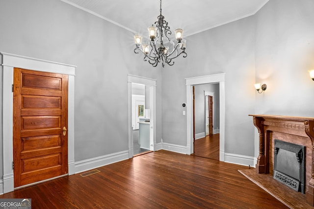 unfurnished living room featuring visible vents, a fireplace, baseboards, and wood finished floors