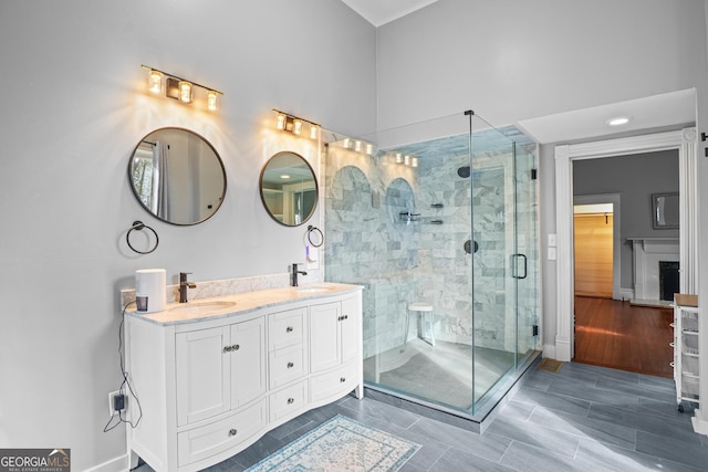 full bath featuring a stall shower, a sink, and double vanity