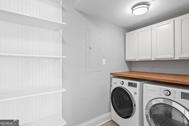 laundry area featuring baseboards, independent washer and dryer, cabinet space, and electric panel