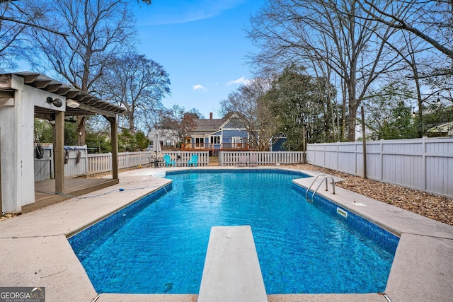 view of pool featuring a fenced backyard, a diving board, a fenced in pool, and a wooden deck