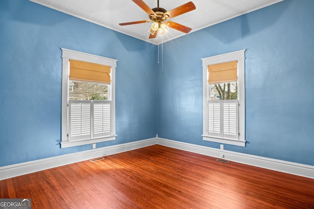 spare room with plenty of natural light, wood-type flooring, and baseboards