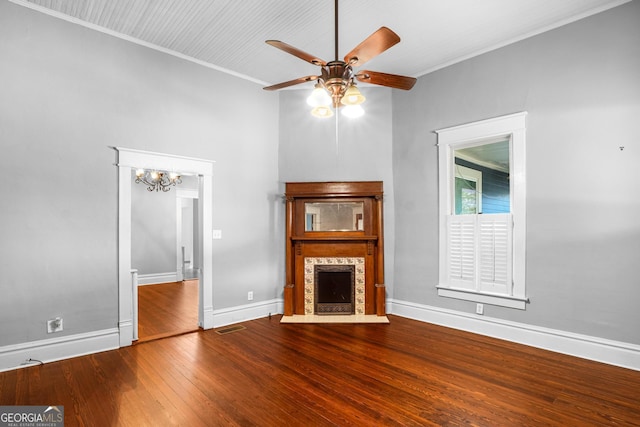 unfurnished living room with crown molding, wood-type flooring, visible vents, a tiled fireplace, and baseboards