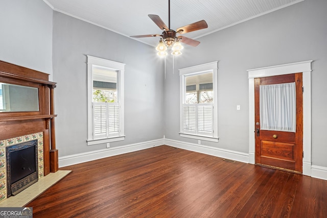 unfurnished living room featuring a fireplace, visible vents, ornamental molding, wood finished floors, and baseboards