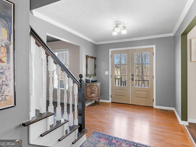 entrance foyer featuring a wealth of natural light, french doors, hardwood / wood-style flooring, and stairs