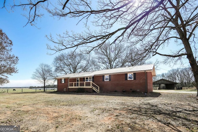 single story home with metal roof, brick siding, crawl space, and fence