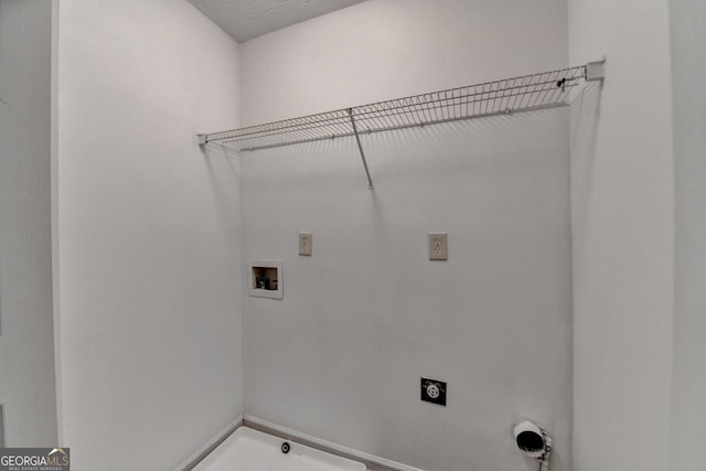 washroom with electric dryer hookup, hookup for a washing machine, and laundry area