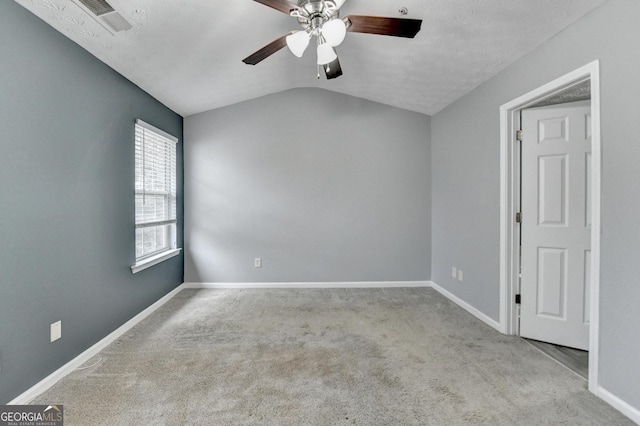 unfurnished room with baseboards, lofted ceiling, carpet, and visible vents