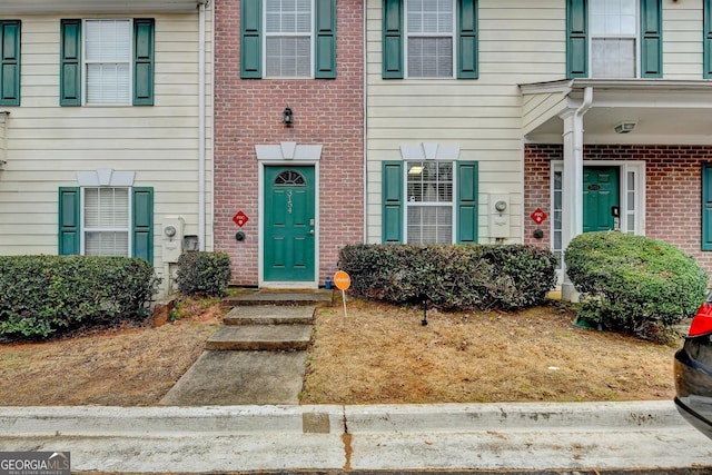 view of exterior entry featuring brick siding