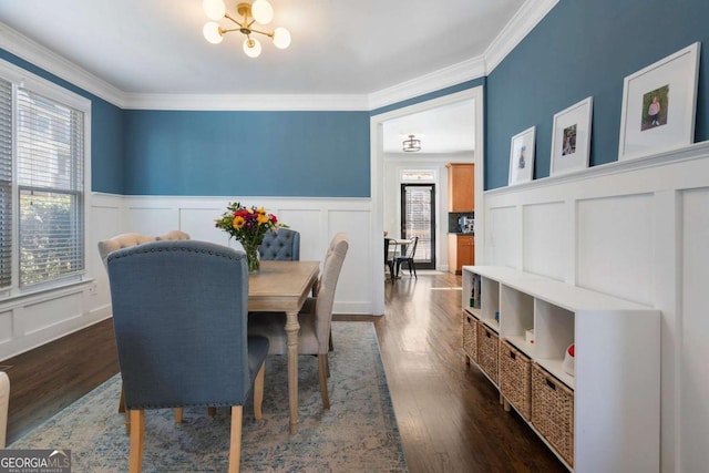 dining room with ornamental molding, dark wood-type flooring, and a notable chandelier