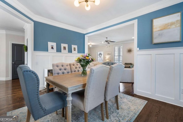 dining space with dark wood-style floors, wainscoting, and crown molding