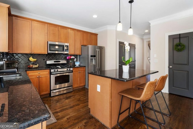 kitchen with a kitchen island, appliances with stainless steel finishes, dark wood finished floors, and backsplash