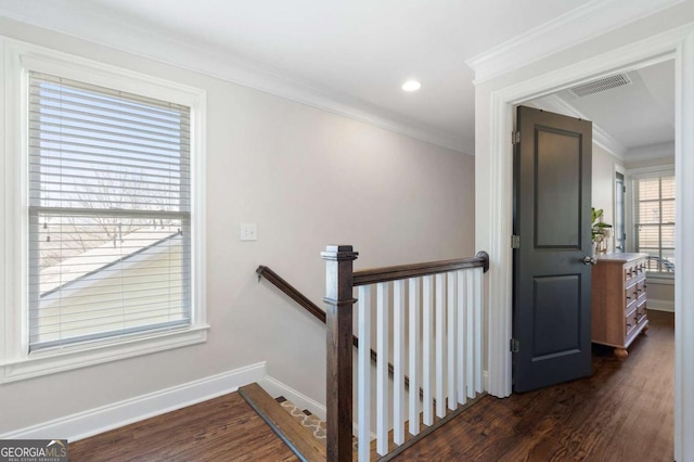 stairway with ornamental molding, wood finished floors, and baseboards