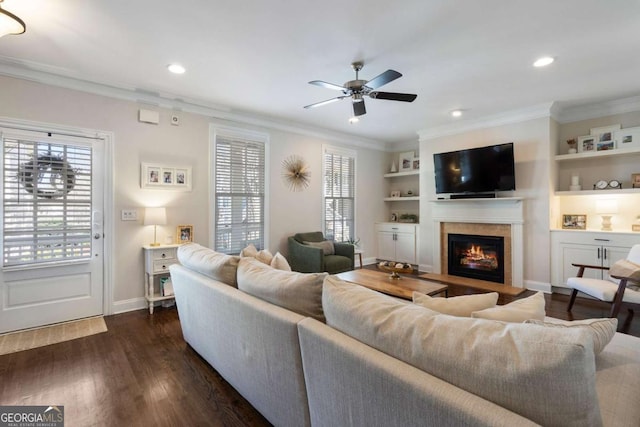 living area featuring plenty of natural light, ornamental molding, and dark wood finished floors