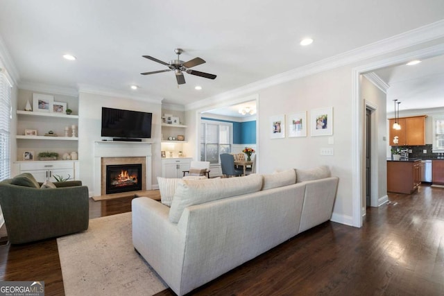 living area featuring recessed lighting, baseboards, dark wood-type flooring, and a glass covered fireplace