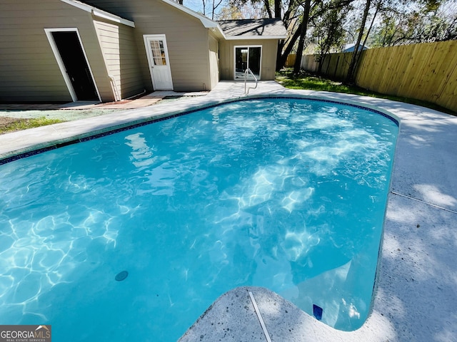 view of swimming pool featuring fence, a fenced in pool, and a patio