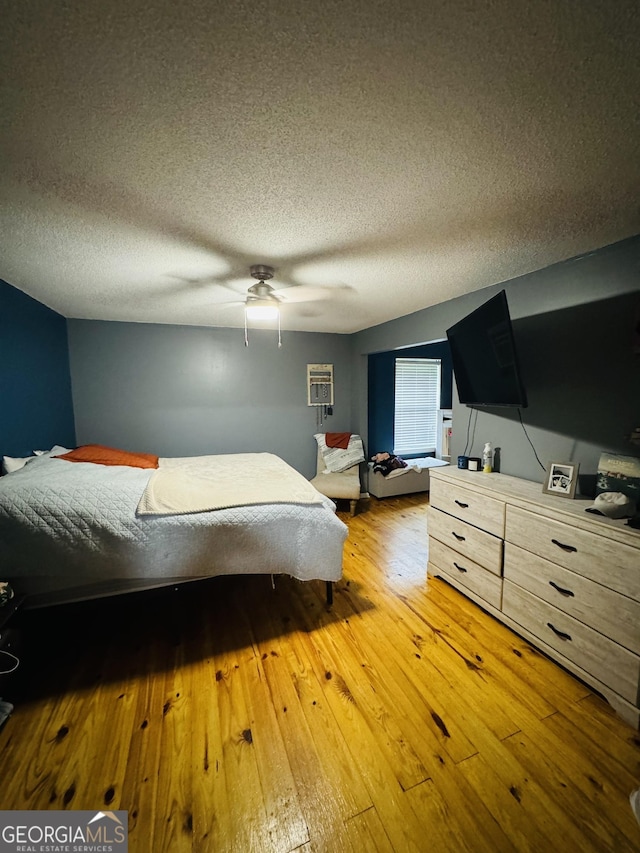 bedroom featuring a textured ceiling, ceiling fan, and light wood-type flooring